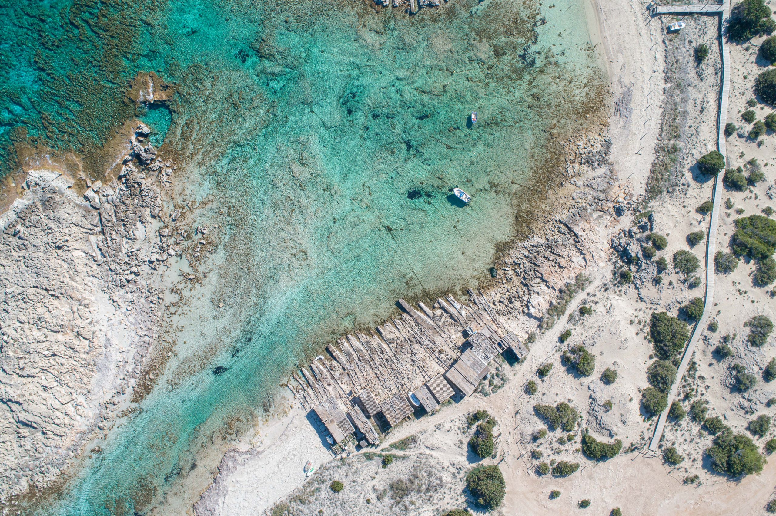 Sunny,Beach,Day,With,Rocks,And,Traditional,Wooden,Huts,Seen